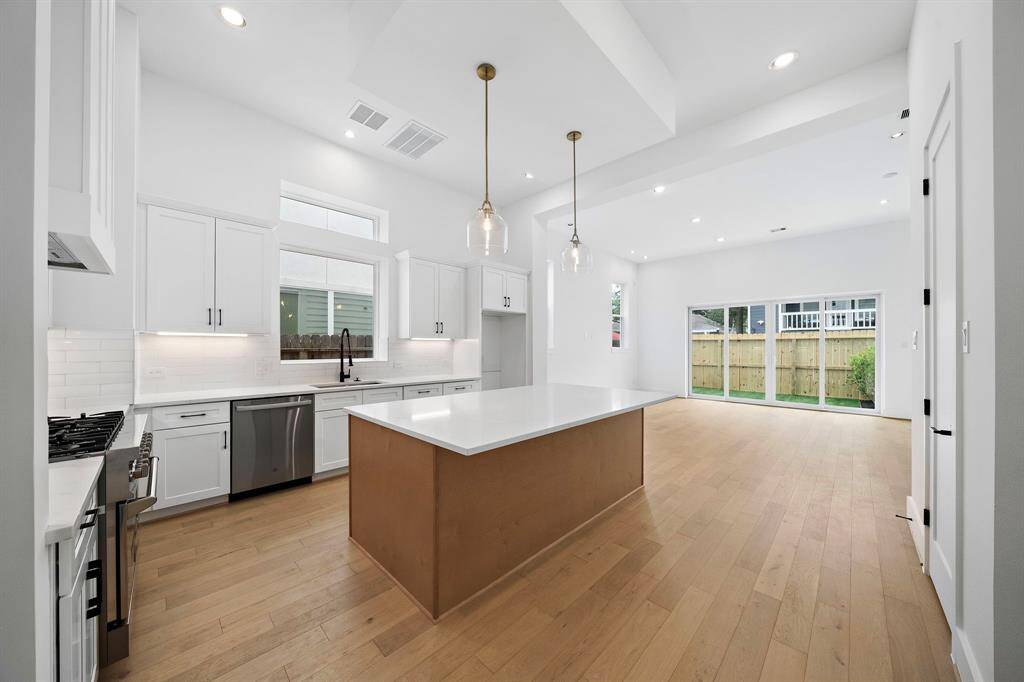 Gorgeous island kitchen with quartz counters, stainless appliances, and plenty of storage space. (Photo is of a previously completed home.)