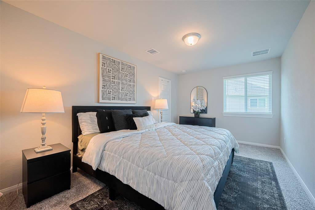 This cozy bedroom has a large window for natural light creating a warm and inviting atmosphere.