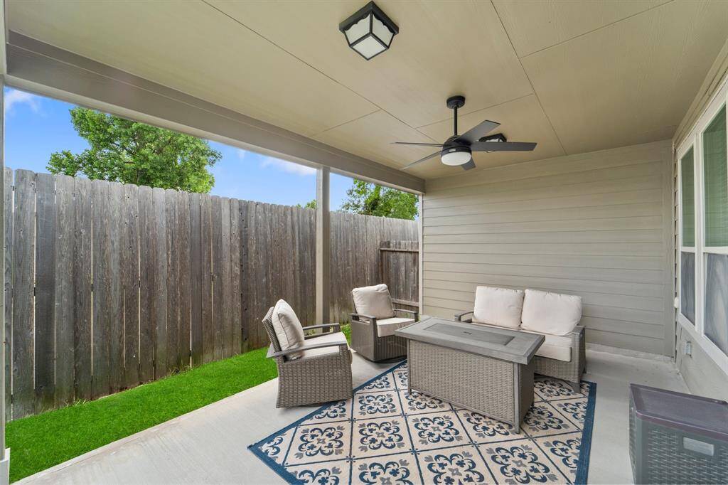 Spacious covered patio with ceiling fan and plenty of room for outdoor seating—ideal for year-round enjoyment.