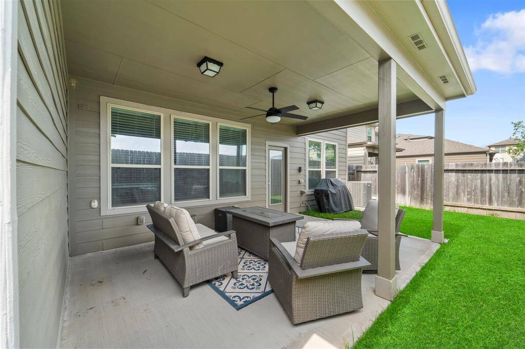 Generously sized covered patio perfect for outdoor dining or relaxing—complete with ceiling fan and built-in gas line for effortless grilling.