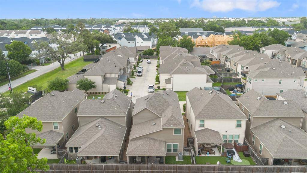 Bird’s-eye look at private backyards and covered patios—plus a glimpse at the community’s peaceful, low-traffic layout near major Houston thoroughfares.