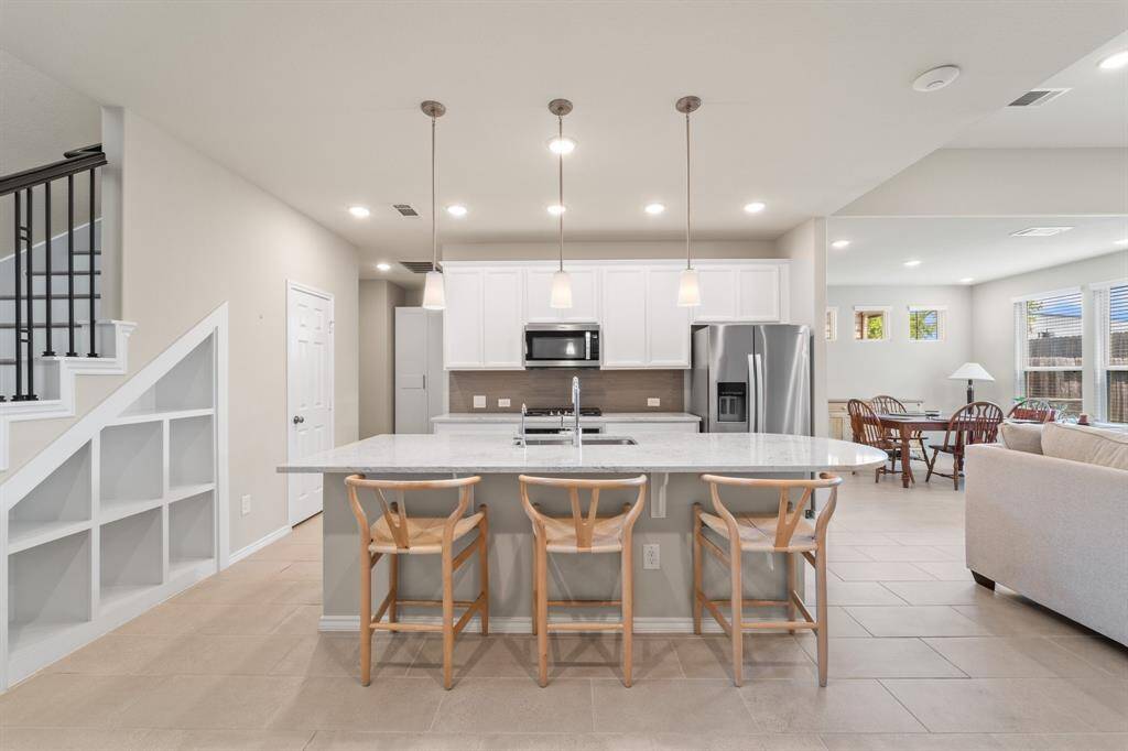 Open-concept kitchen with oversized island, pendant lighting, and built-in seating—flows effortlessly into the living and dining areas for easy everyday living and entertaining.