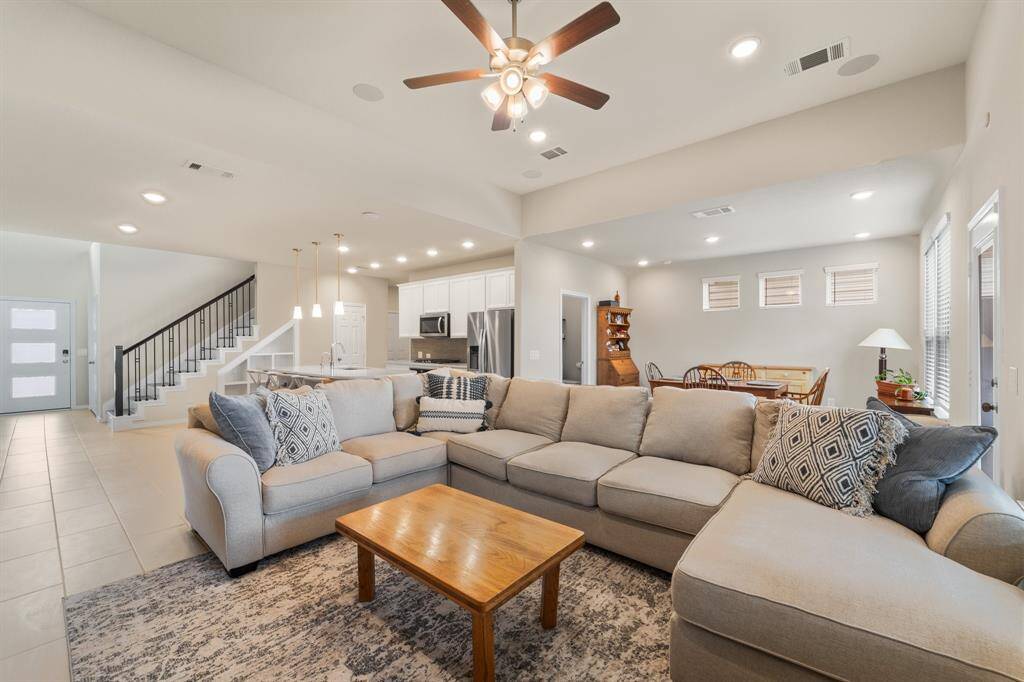 Open-concept living connects seamlessly to the kitchen and dining areas—neutral tones and tile flooring enhance the home’s flow and flexibility.