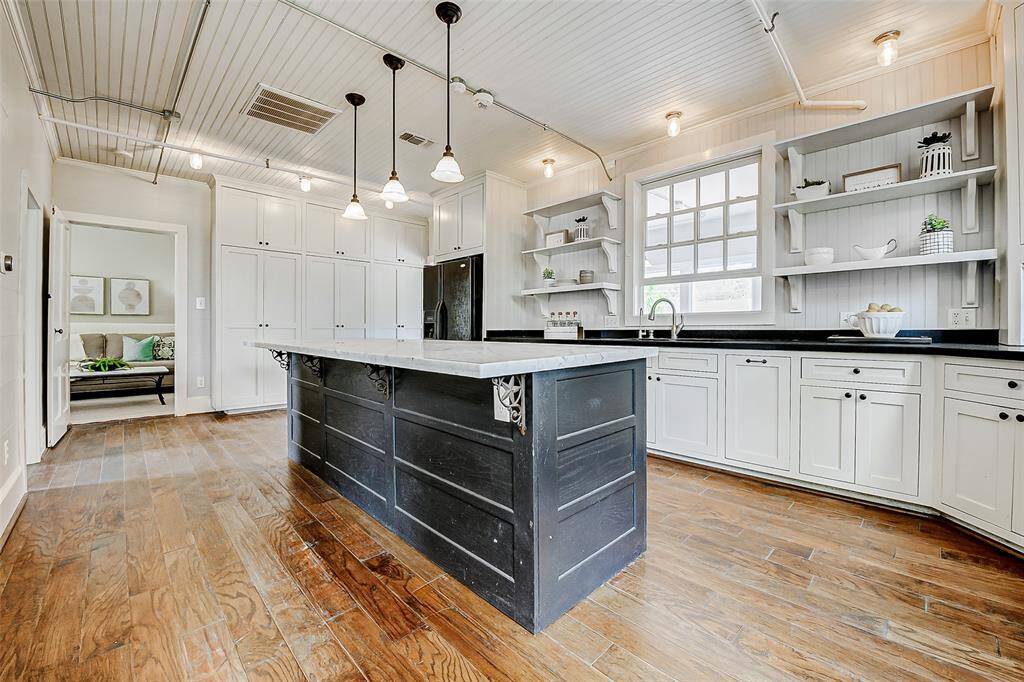 Original charm combined with modern conveniences! This spacious 11x22 kitchen is perfect for catering or entertaining. It includes expansive storage and 11' marble island.