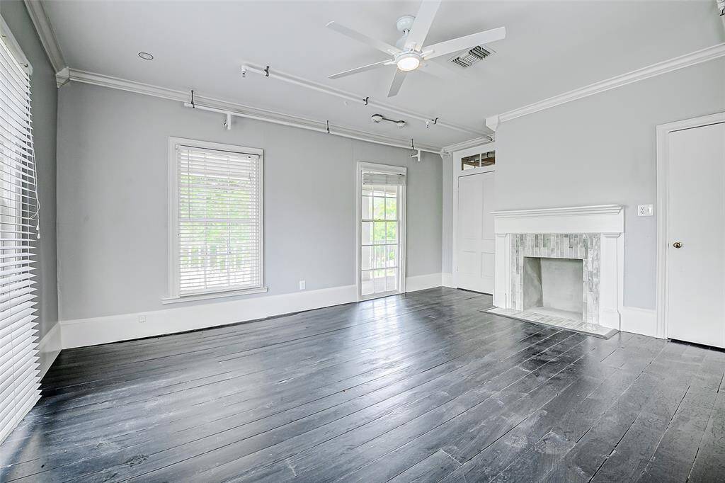 This spacious room is bathed in natural light and features a recently restored fireplace, complemented by a ceiling fan for added comfort.