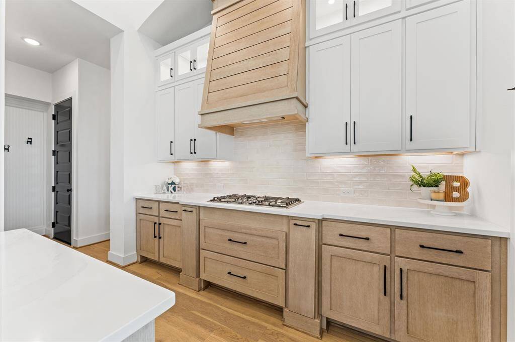 A stylish backsplash complements the sleek stainless steel appliances.