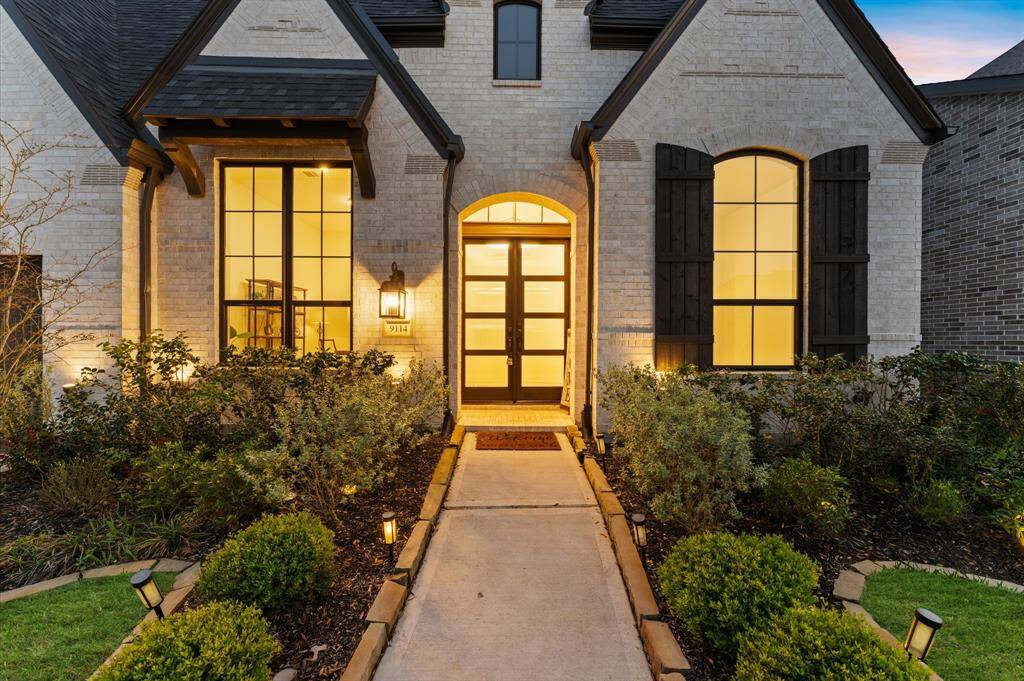 A wide pathway leads to the front door, creating a warm and elegant entrance.