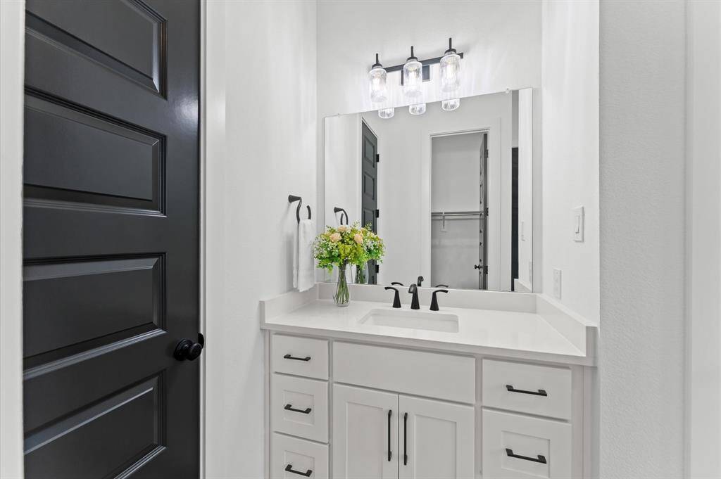 A beautifully designed bathroom featuring a sleek vanity with plenty of storage.