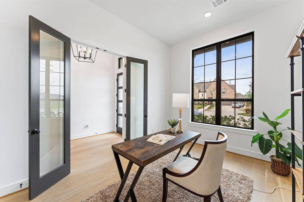 French doors open to the study designed for productivity and creativity while the wide window welcomes the morning sun, creating an inspiring atmosphere.