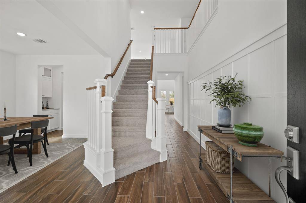 Welcoming foyer with feature wall and elegant staircase (*Photo not of actual home and used for illustration purposes only.)