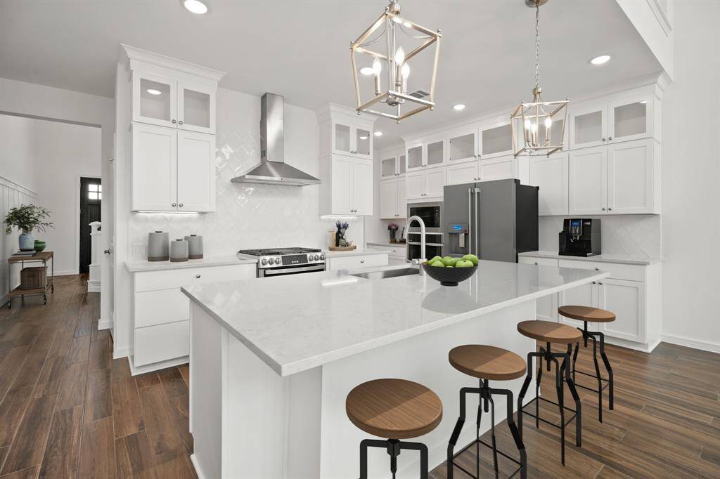 Stunning kitchen with quartz countertops and stacked glass front cabinets (*Photo not of actual home and used for illustration purposes only.)