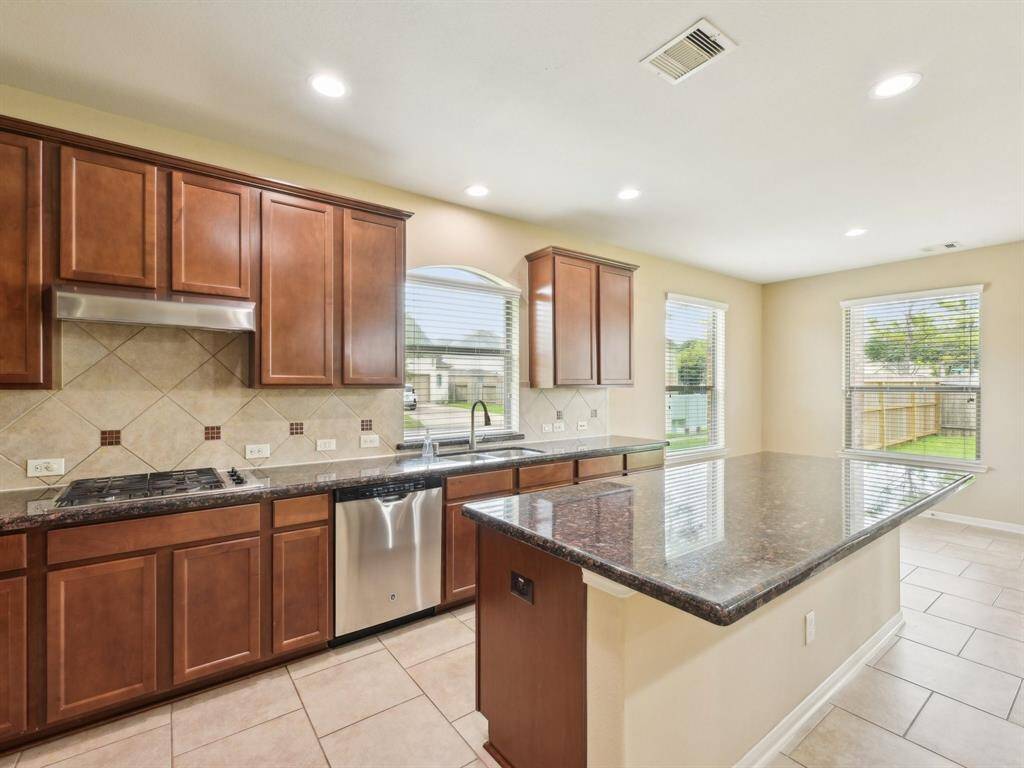 The beautiful tile backsplash has a decorative inlay.