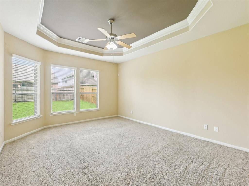 The spacious and private Primary Bedroom has a wonderful tray ceiling and crown molding.
