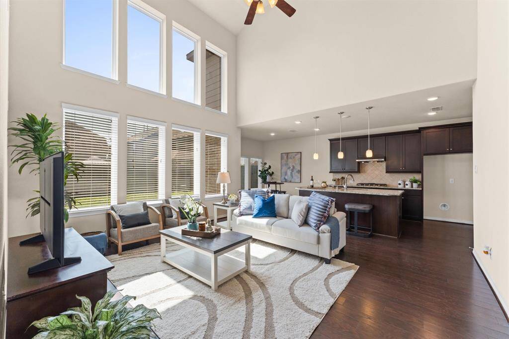 Soaring ceilings and tall windows fill the living room with light and warmth.