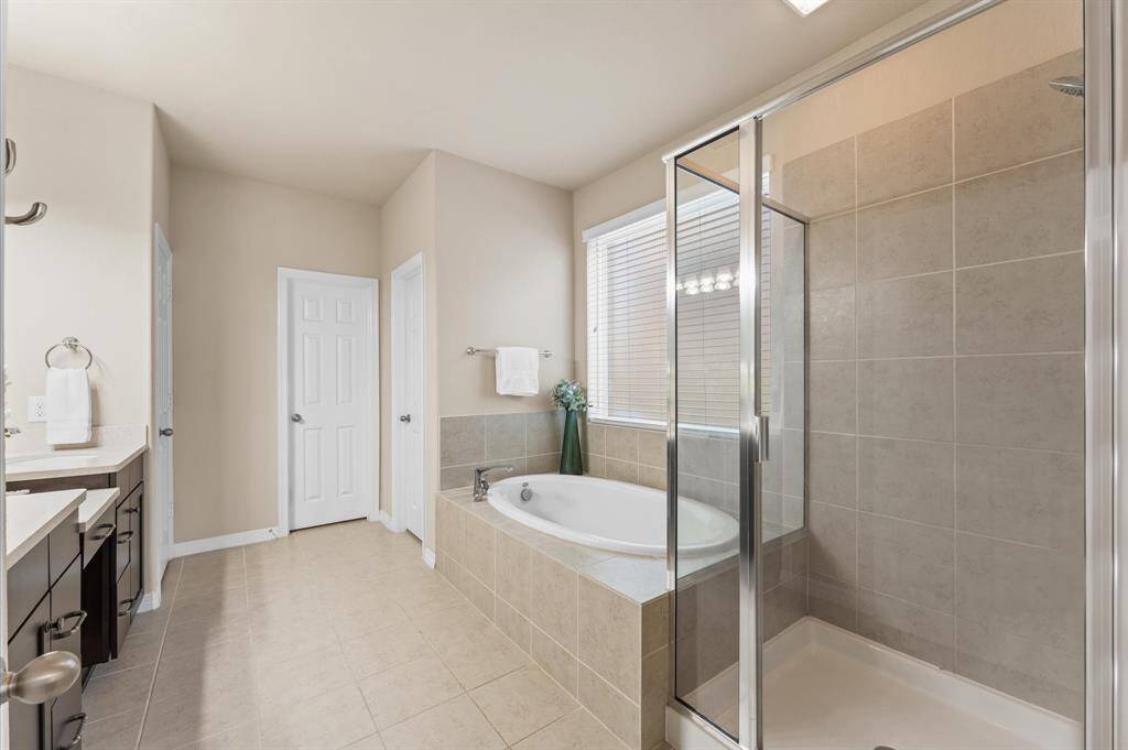 A separate glass-enclosed shower adds a touch of modern comfort and convenience.