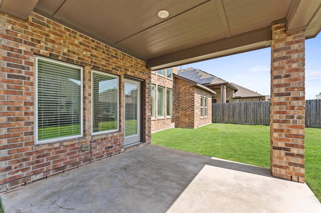 Step out to a covered patio overlooking a lush, green yard.