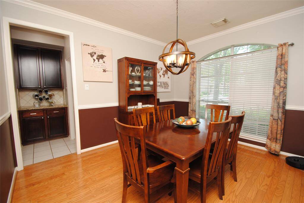 The open layout flows seamlessly into the dining area and kitchen, creating an inviting space for entertaining. A staircase leads to the upper level, enhancing the open feel.