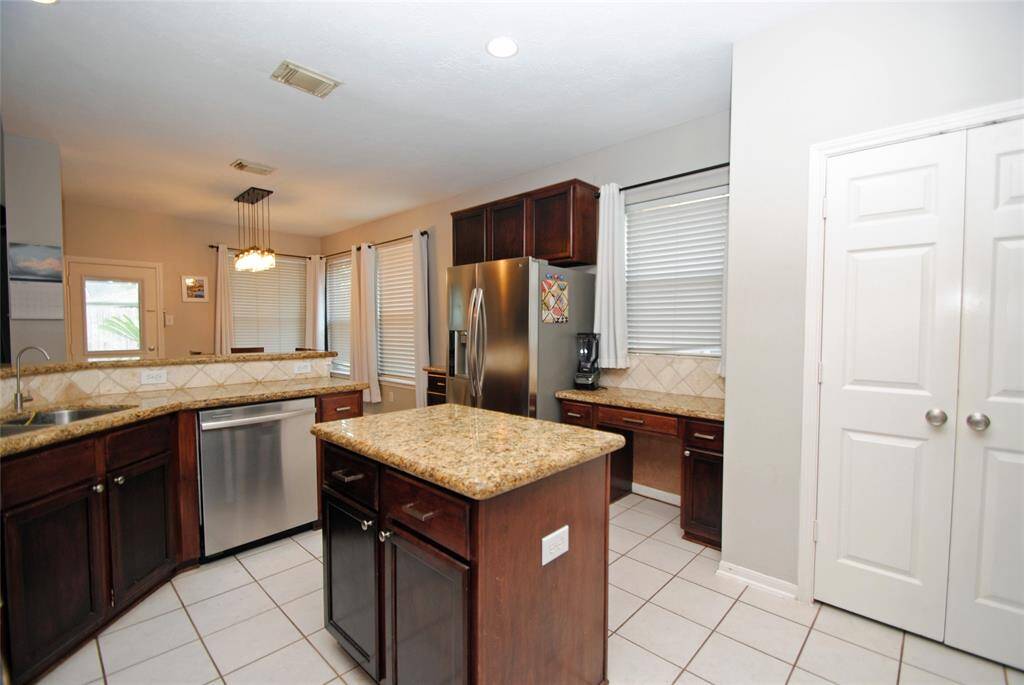The dining room has two-toned walls with crown molding and a window letting in natural light.