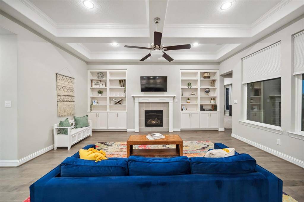 The built-in shelving adds charm and function, while the elegant fireplace serves as the focal point—imagine cozy evenings here, surrounded by everything that makes a house feel like home.