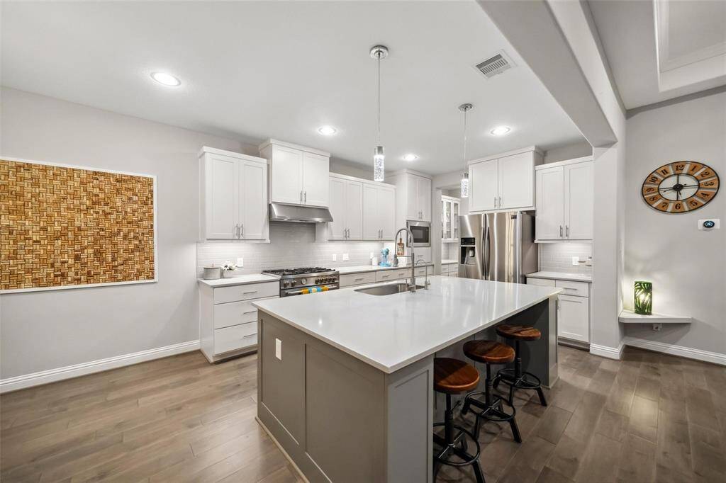 The oversized island doubles as a breakfast bar, making it easy to entertain or enjoy casual meals. With high ceilings and generous space, this kitchen feels as open as it is welcoming.