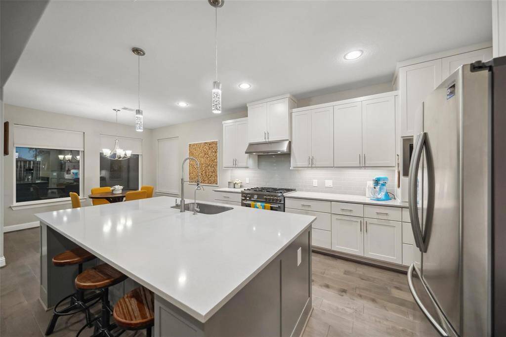Sleek white cabinetry, stainless steel appliances, and deep pots-and-pans drawers combine to offer a modern kitchen that’s as practical as it is beautiful.