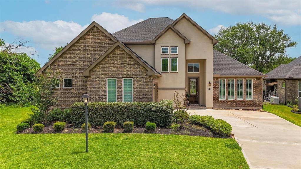 An expansive driveway guides you toward the home's charming facade, beautifully accented by a classic lamp post.