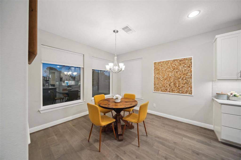 The breakfast nook is bathed in natural light from large windows and enhanced by an elegant light fixture—creating a cozy, welcoming space for daily meals.