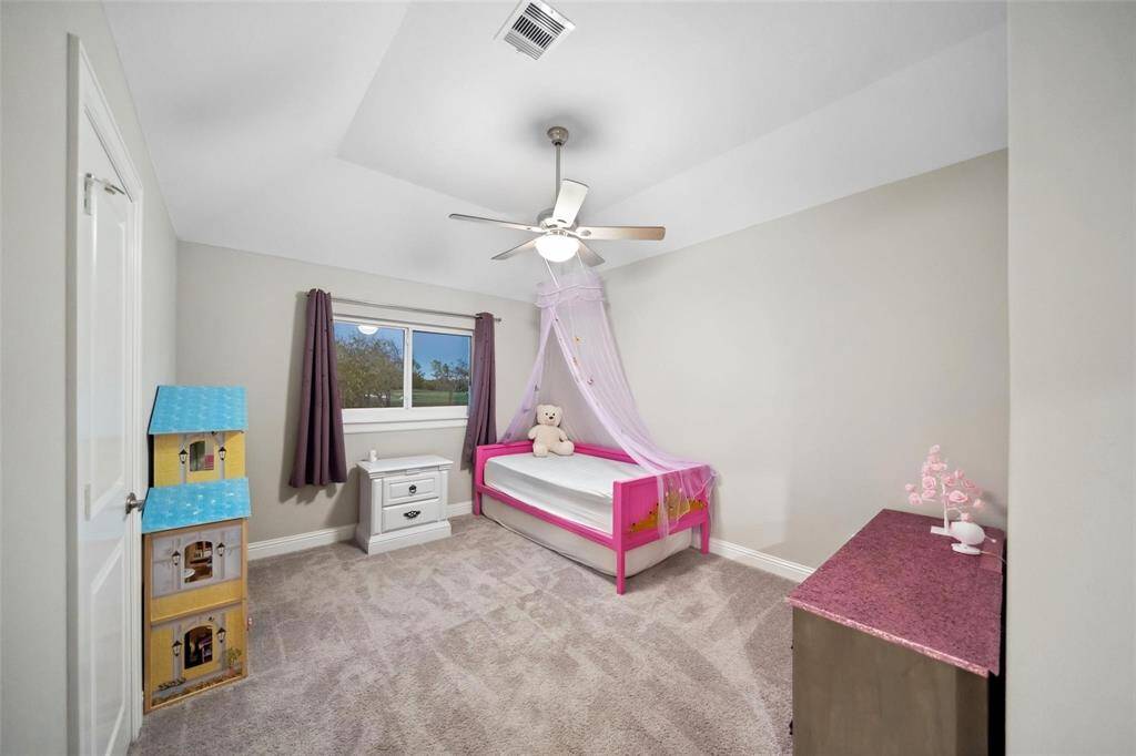 The secondary bedroom upstairs features high ceilings and abundant natural light, offering plenty of room for comfortable living or hosting guests.