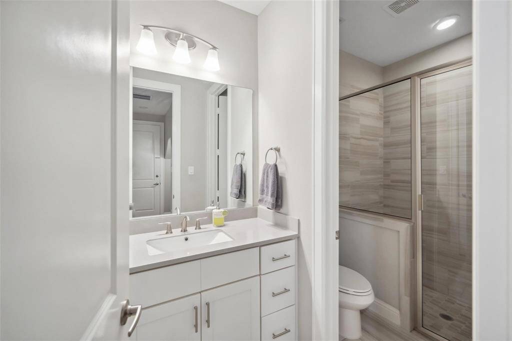 Another secondary bathroom features a spacious shower and practical design, ideal for busy mornings and guest use.
