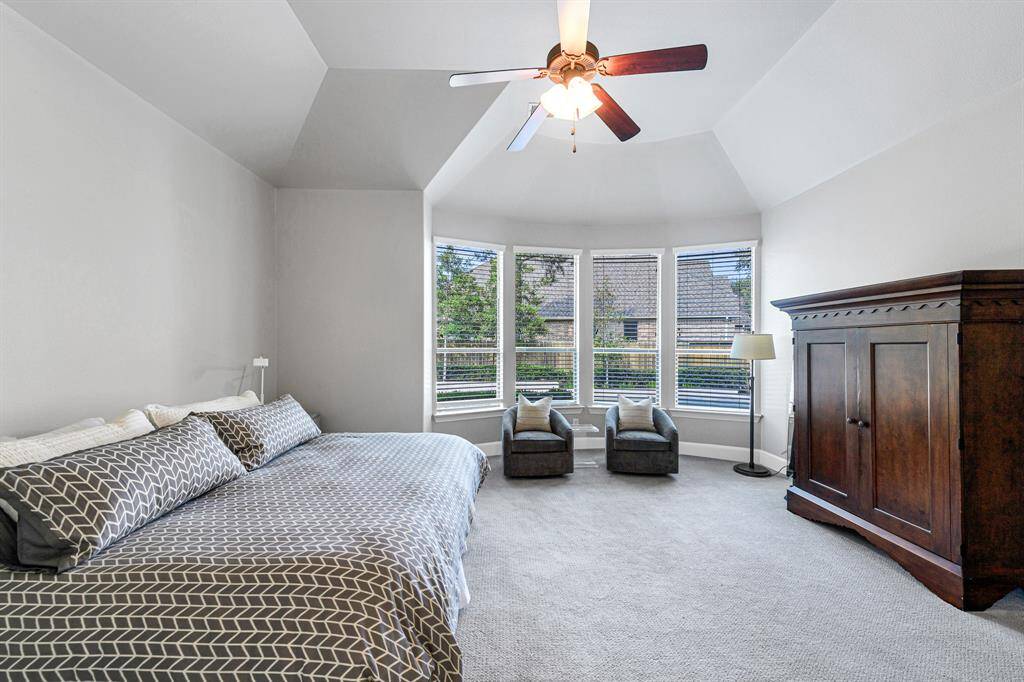 Another view of the primary bedroom. High ceilings and a view of the beautiful backyard highlight this space.