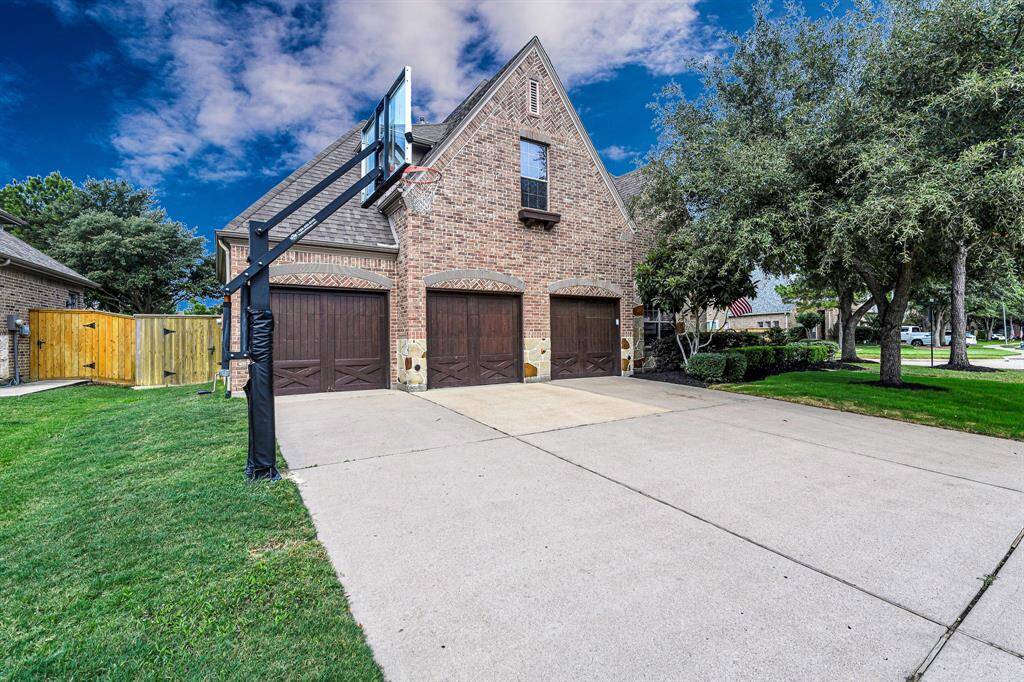 Spacious driveway complete with in ground basketball hoop. Three car garage with extra storage. Plenty of room for cars and driveway fun!
