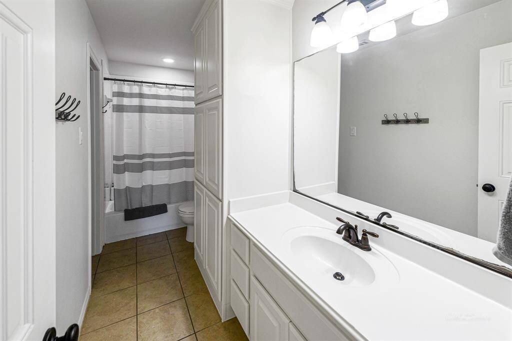 Private en-suite bathroom for upstairs bedroom #1.  Notice the large mirror and ample vanity space.  Tub/shower combo here with the closet on the left side.