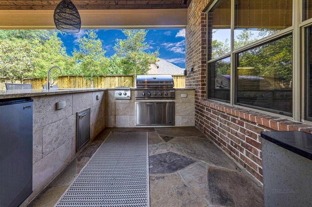 Another view of the awesome outdoor kitchen complete with sink, fridge, grill and more.