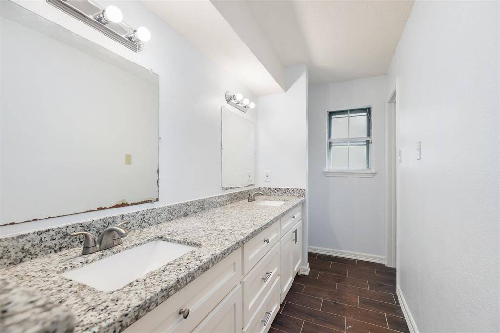 The primary ensuite features dual sinks, generous cabinet storage, and sleek marble countertops—combining function and style in a private setting.
