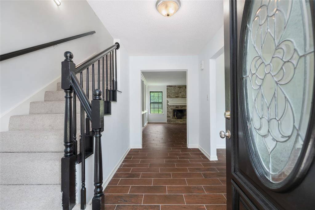 Step through the front door into a freshly painted interior where a classic staircase anchors the formal entryway, setting the tone for the charm and elegance found throughout the home.