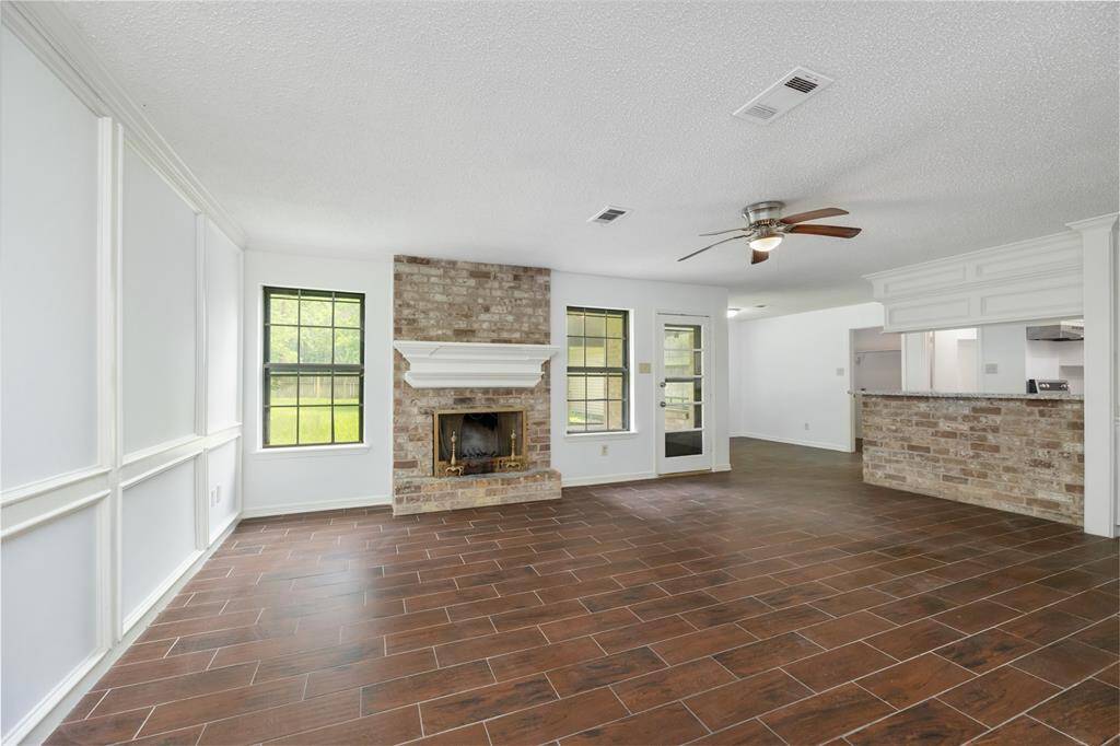 Full of character, this inviting space showcases custom board and batten walls and an exposed brick fireplace with a timeless mantle—an ideal blend of warmth and style.