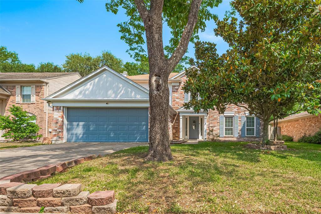 This lovely home is surrounded by mature trees.