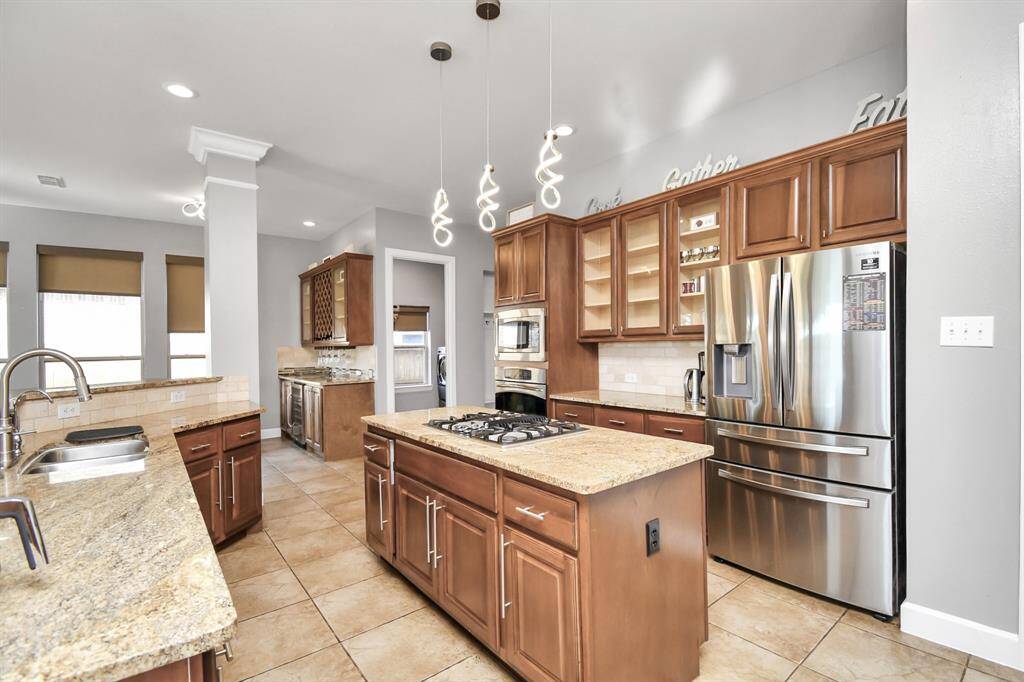 The kitchen is designed with an open floor plan, allowing for a seamless flow between cooking, dining, and entertaining areas. It features a combination of custom cabinetry, high-end appliances, and expansive countertops, providing both ample storage and workspace.