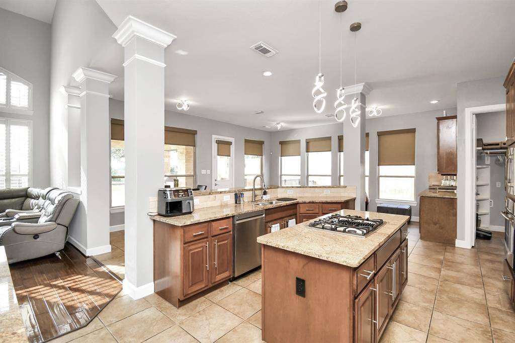 The kitchen features an open-plan design that seamlessly integrates with adjacent living and dining areas. The layout ensures a fluid flow between different zones, allowing for easy movement and interaction. The space is characterized by its generous size, which enhances both functionality and comfort.