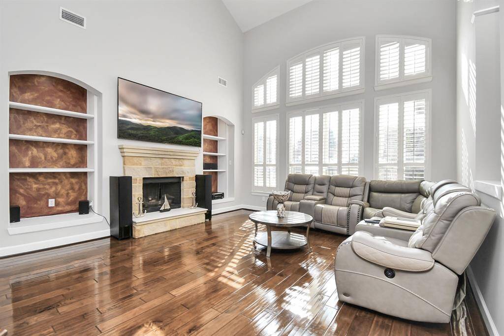 This grand living room is a striking example of elegance and space, characterized by its impressive high ceilings and sophisticated design. It is designed to be a central gathering space that exudes both comfort and grandeur.