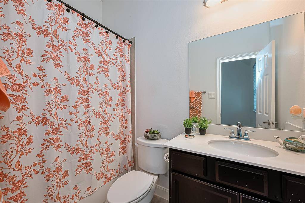 Secondary bathroom features a sink with ample cabinets and a shower & tub combo.