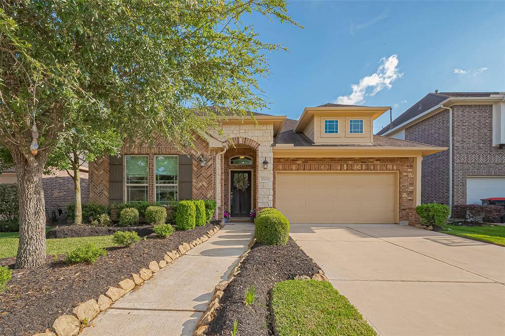This stunning family room features a charming fireplace as the focal point, complemented by rich wood flooring and expansive windows that fill the space with natural light.