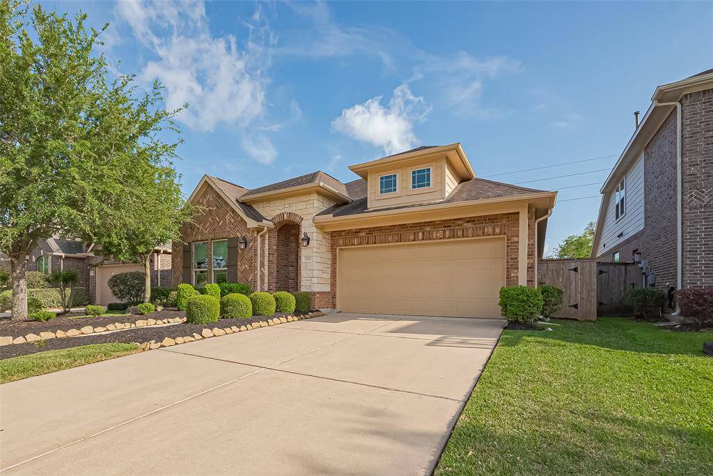 This stunning home boasts charming curb appeal with a beautiful brick and stone facade.