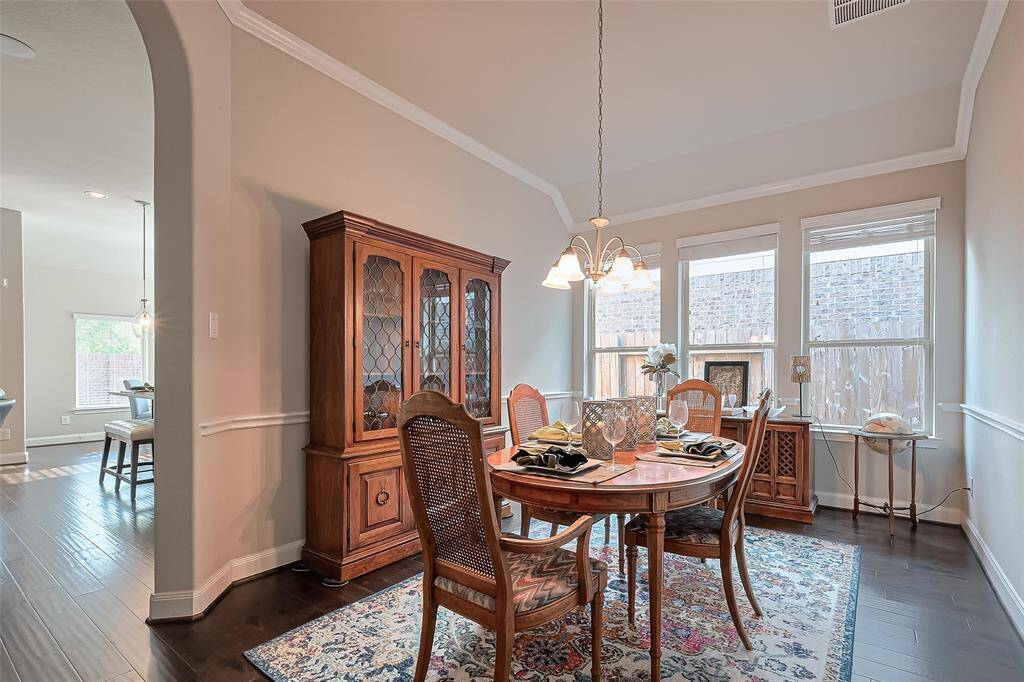The primary bedroom is a true retreat, featuring elegant crown molding, plush carpet flooring and a seating area perfect for relaxation.