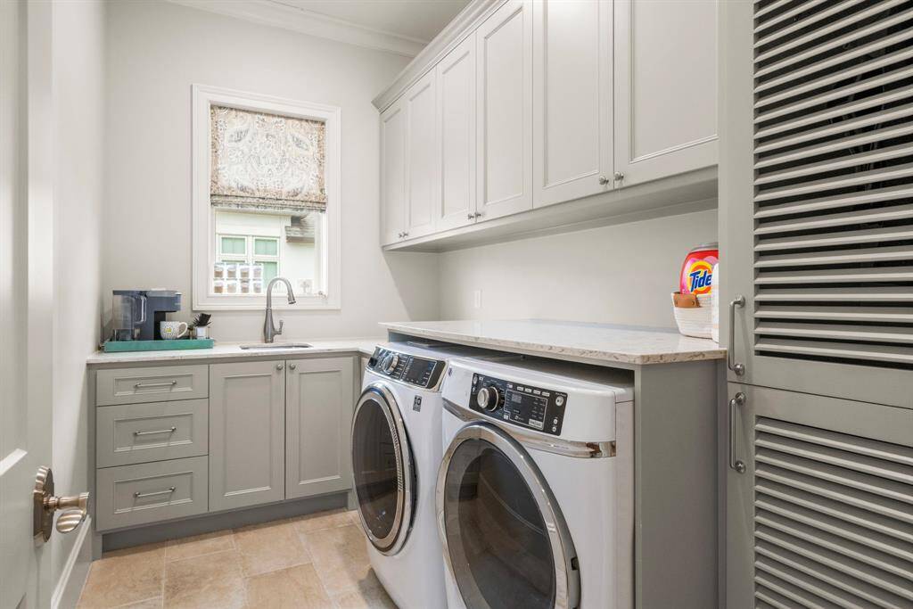 LAUNDRY ROOM - Second floor laundry room where function meets design. Custom cabinets for plenty of storage and closet with louvered doors to allow air flow while concealing hanging garments.