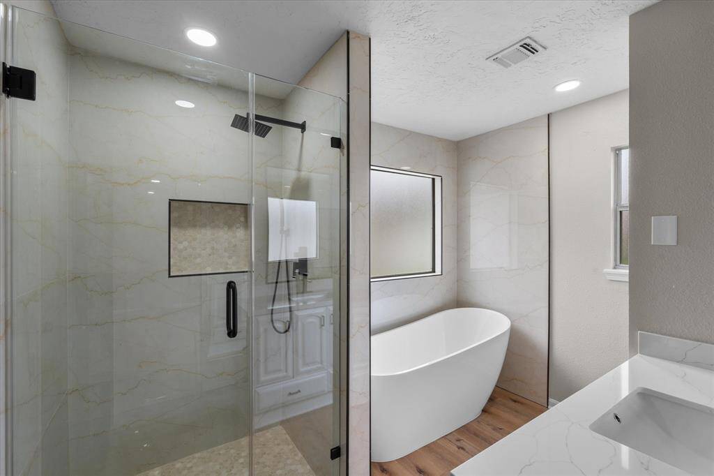 Primary ensuite bathroom with over sized freestanding tub, beautiful tile throughout