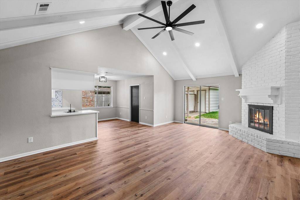 Huge vaulted ceiling living room with recessed lighting, over sized fan and gas fireplace