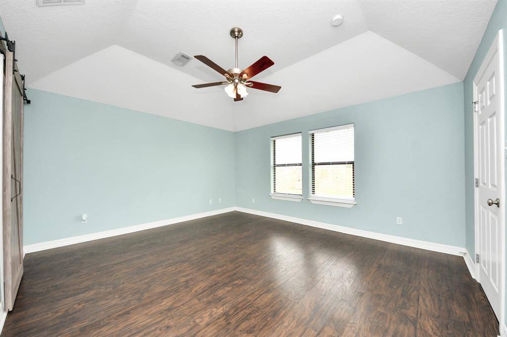 Primary Bedroom with a view of the backyard and sliding barn door to the ensuite bathroom