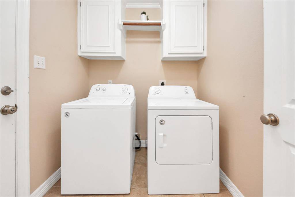 Laundry room with built-in shelving and rods, situated between the front entry and garage entrance.
