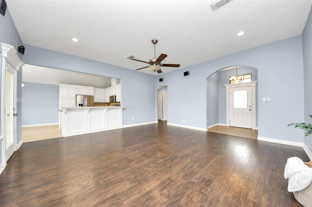 Open concept living room with a view of the front door and kitchen.